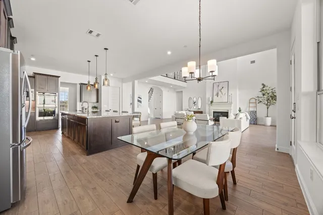 a view of a dining room and livingroom with furniture wooden floor a chandelier