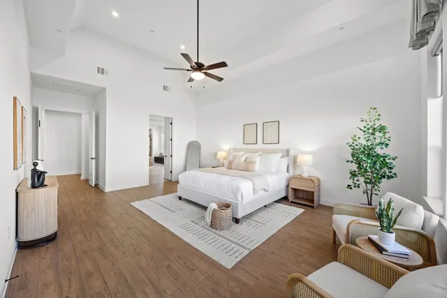 a spacious bedroom with a bed a couch and potted plant