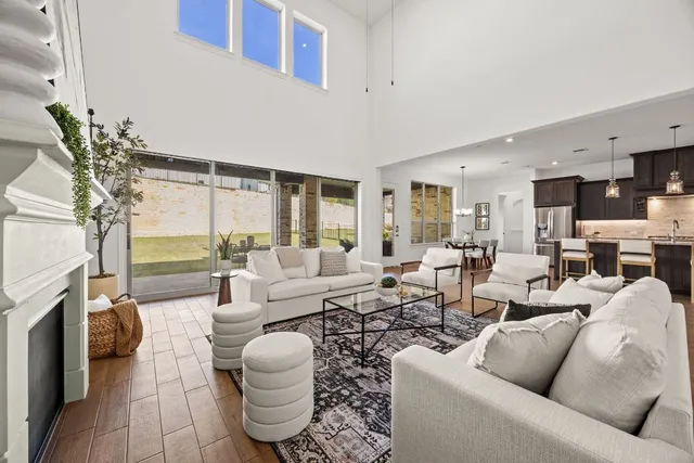 a living room with fireplace furniture and a large window
