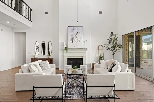 a living room with furniture a fireplace and potted plants with wooden floor