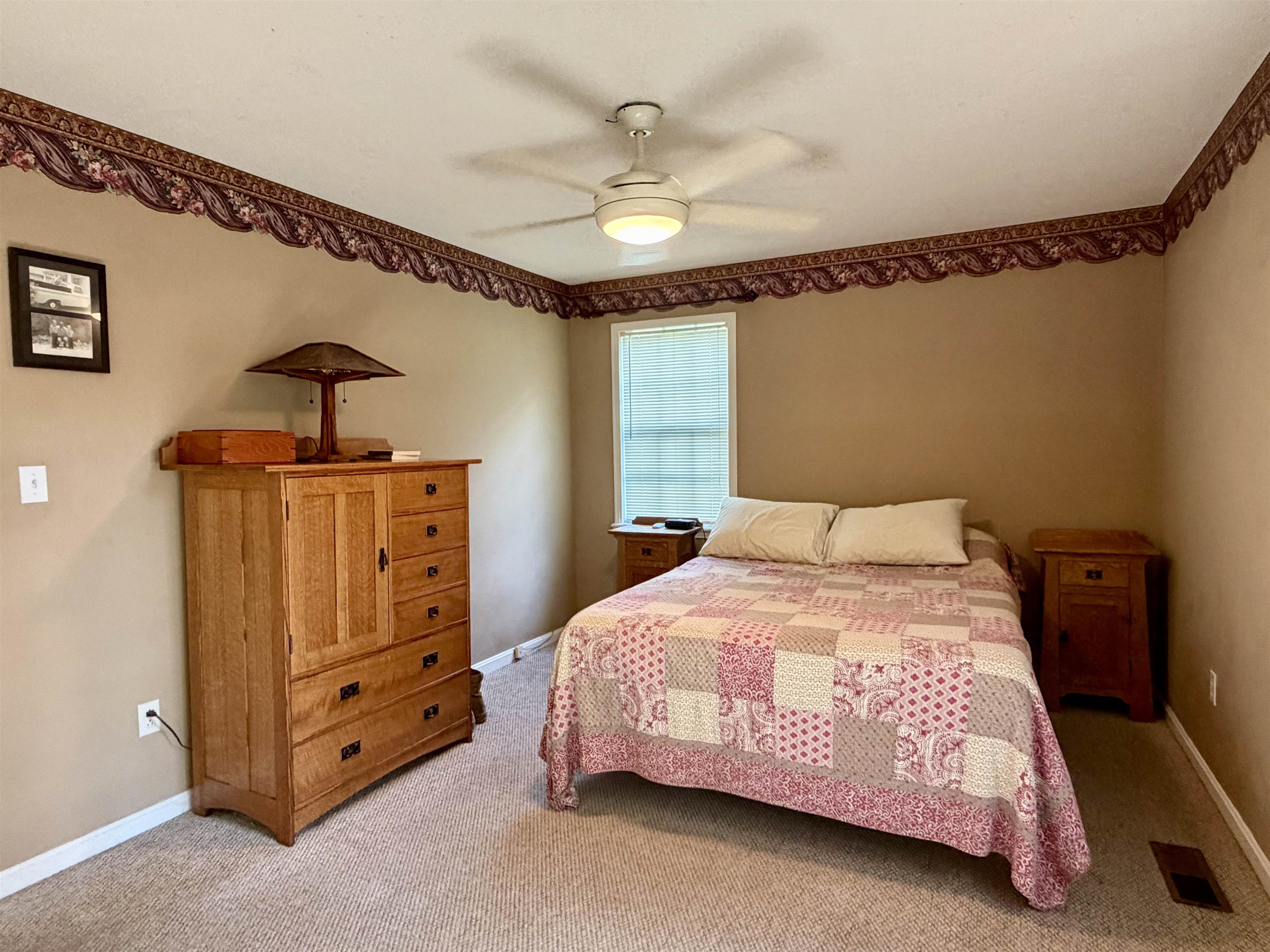 373 Clarence Barham Road Bethel Springs, TN 38315 - Photo 14 of 28 Carpeted room featuring neutral wall paint, a ceiling fan with integrated lighting, a window with blinds, and decorative border trim