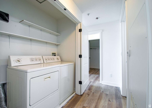 4276 South Main Street, Unit 303 Murray, UT 84107 - Photo 8 of 20 Dedicated laundry area featuring a washer and dryer, complemented by two wall-mounted storage shelves