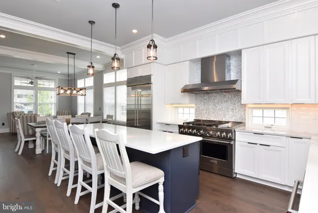 a large kitchen with stainless steel appliances stove a table and chairs