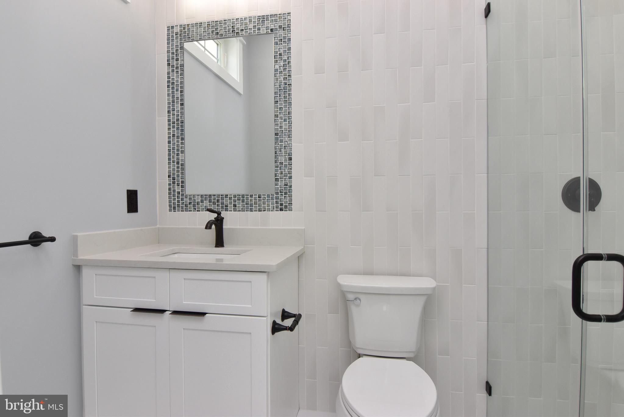 3 Laurel Street Rehoboth Beach, DE 19971 - Photo 16 of 47 a bathroom with a toilet sink and mirror