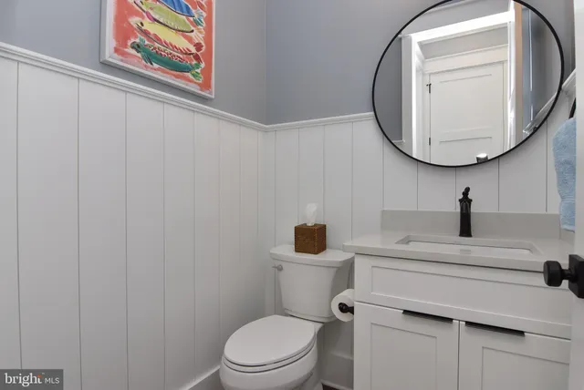 a bathroom with a toilet a sink and a mirror