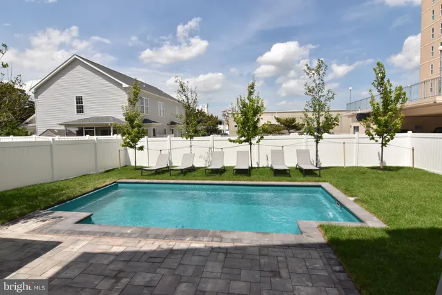 a view of a house with swimming pool and a yard