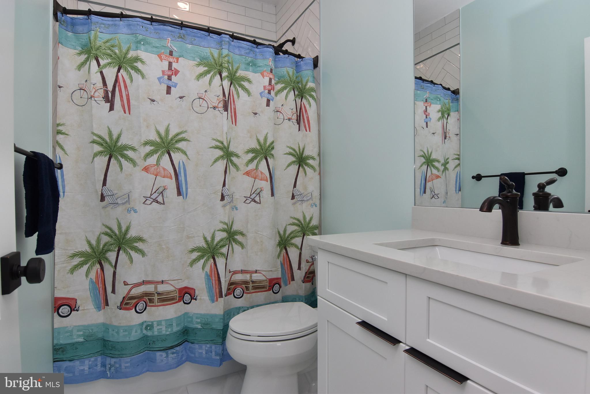 3 Laurel Street Rehoboth Beach, DE 19971 - Photo 35 of 47 a bathroom with a sink a toilet and a mirror