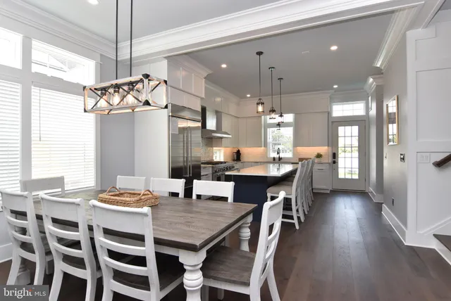 a dining room with a table chairs and kitchen view