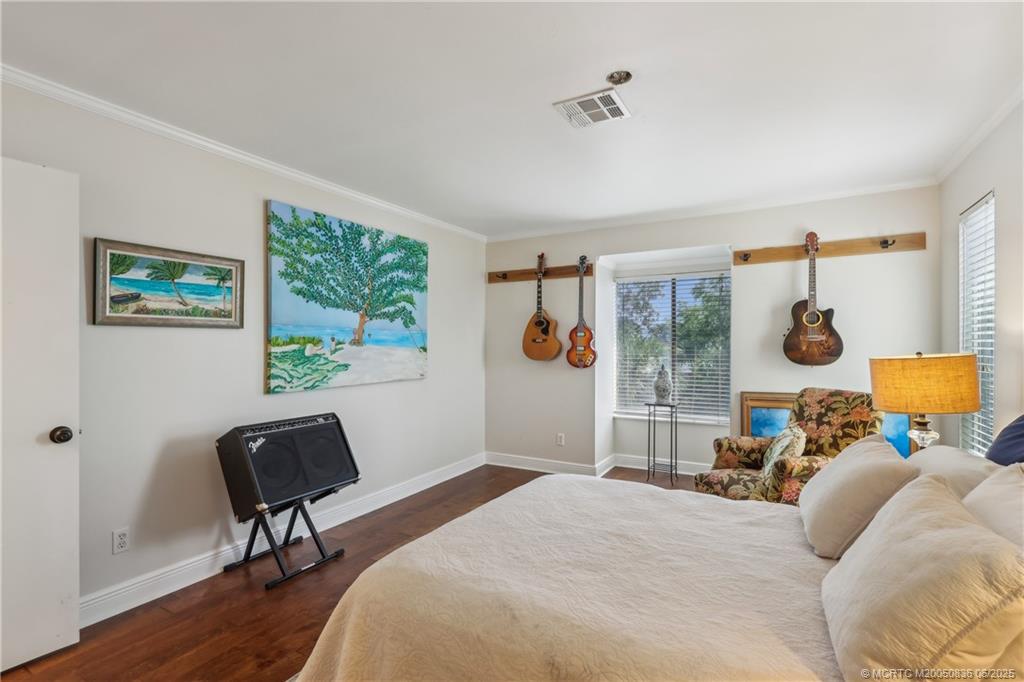 800 Northwest Fork Road, Unit 513 Stuart, FL 34994 - Photo 13 of 30 a bedroom with a bed and wooden floor