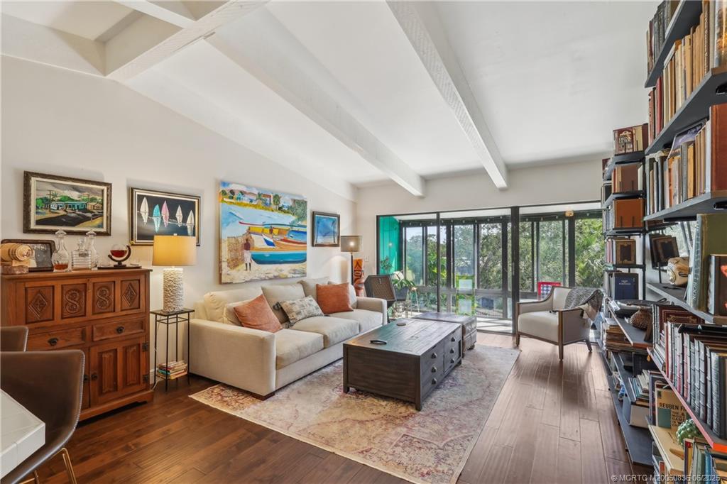 800 Northwest Fork Road, Unit 513 Stuart, FL 34994 - Photo 3 of 30 a living room with furniture a flat screen tv and a floor to ceiling window