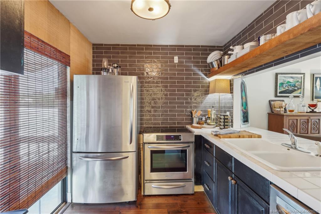 800 Northwest Fork Road, Unit 513 Stuart, FL 34994 - Photo 8 of 30 a kitchen with stainless steel appliances a refrigerator a sink a stove and white cabinets