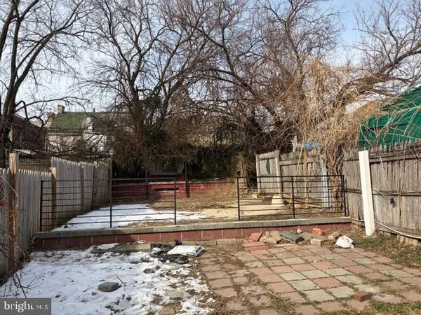 a view of a yard with wooden fence