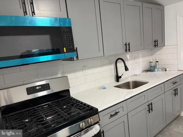 a kitchen with white cabinets and appliances