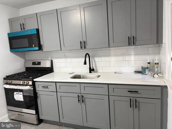 a kitchen with white cabinets and white appliances