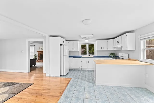 a large white kitchen with wooden floors and white cabinets