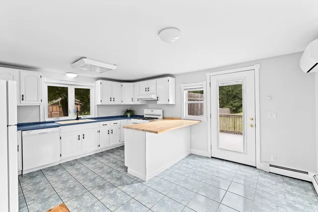a large white kitchen with cabinets and a sink