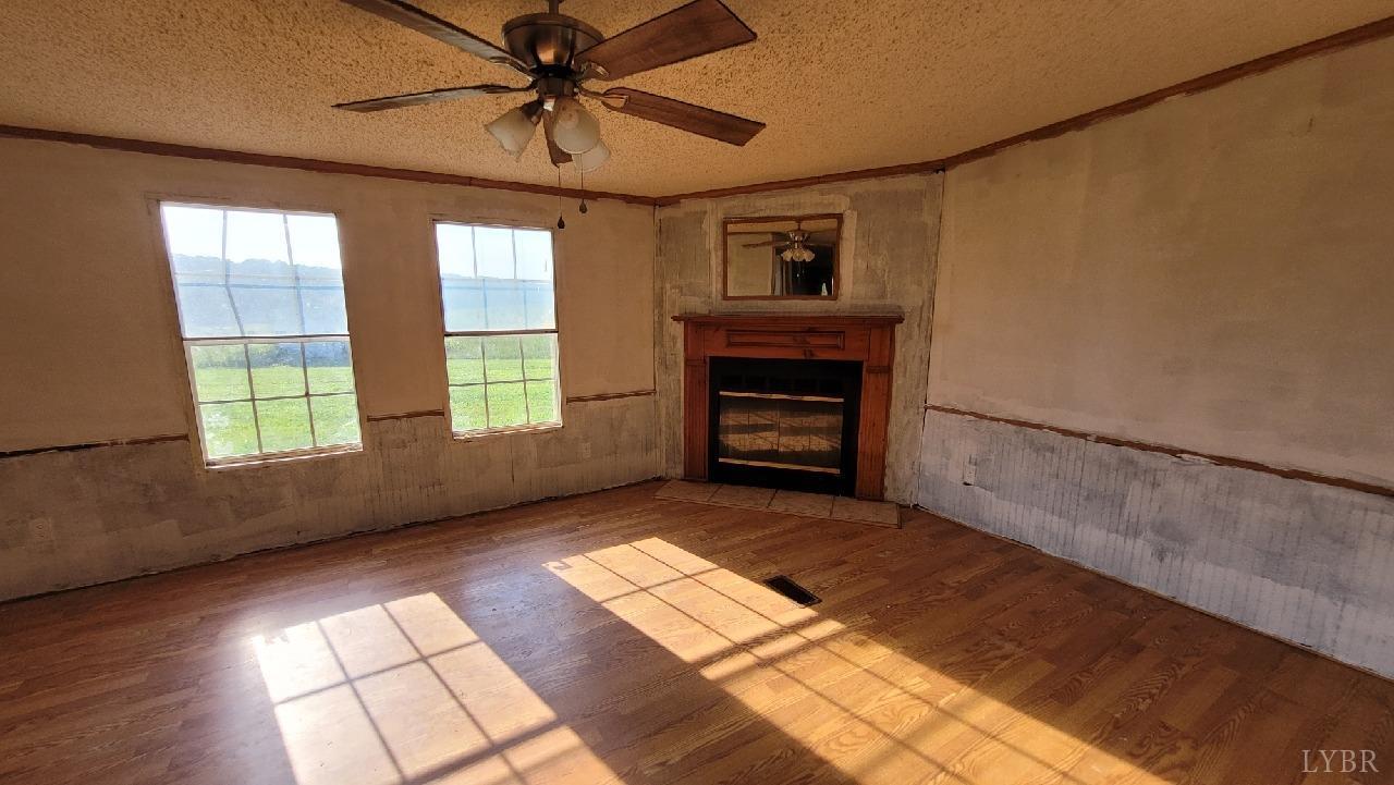1977 Lyle Thomas Road Spout Spring, VA 24538 - Photo 3 of 11 a view of empty room with a fireplace and wooden floor