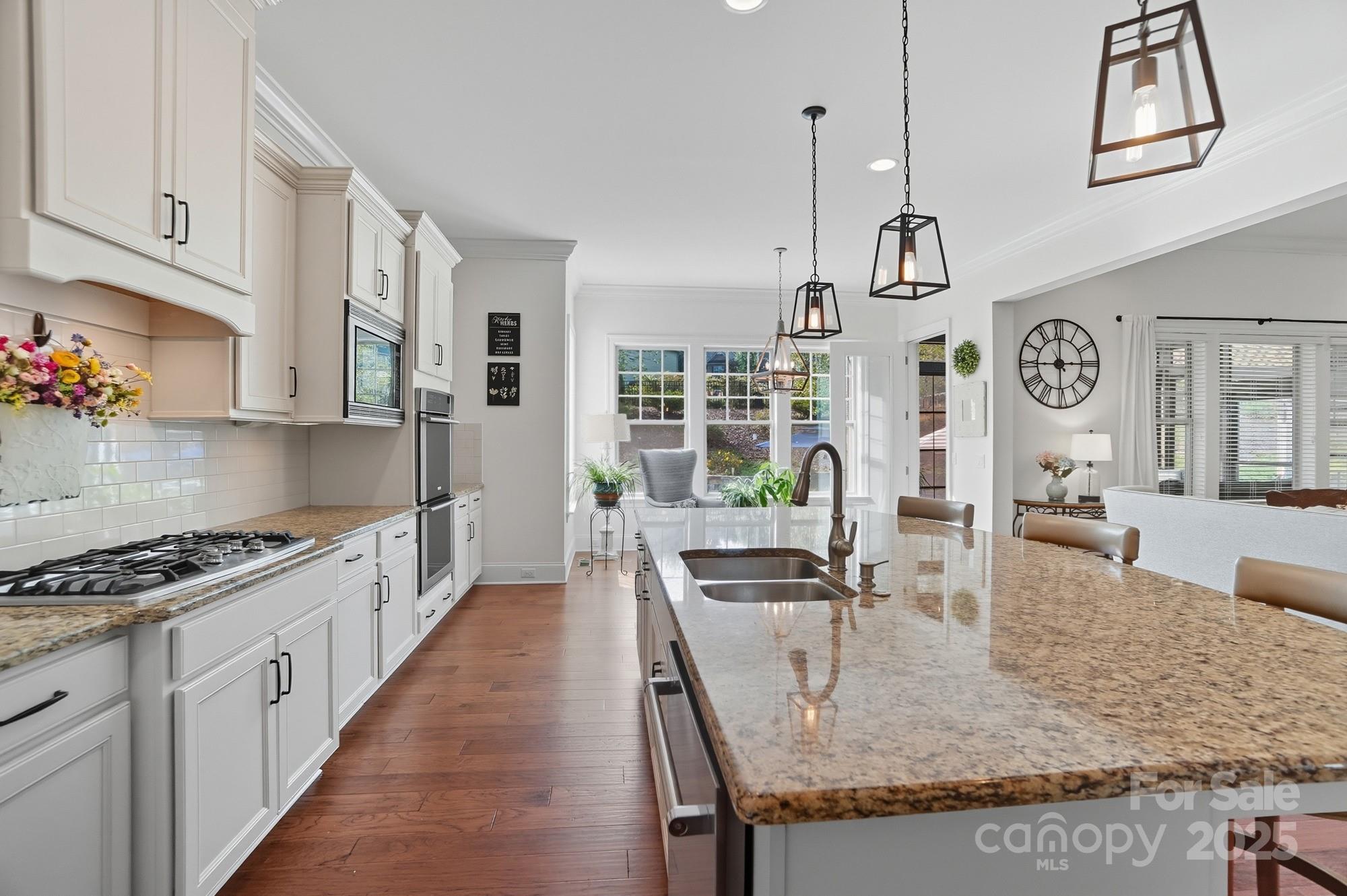 546 Abelia Lane Fort Mill, SC 29708 - Photo 14 of 43 a kitchen with granite countertop a table chairs stove and cabinets