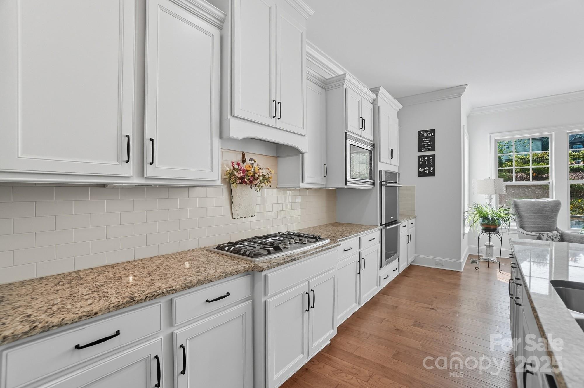 546 Abelia Lane Fort Mill, SC 29708 - Photo 15 of 43 a kitchen with granite countertop a stove a sink dishwasher and cabinets with wooden floor