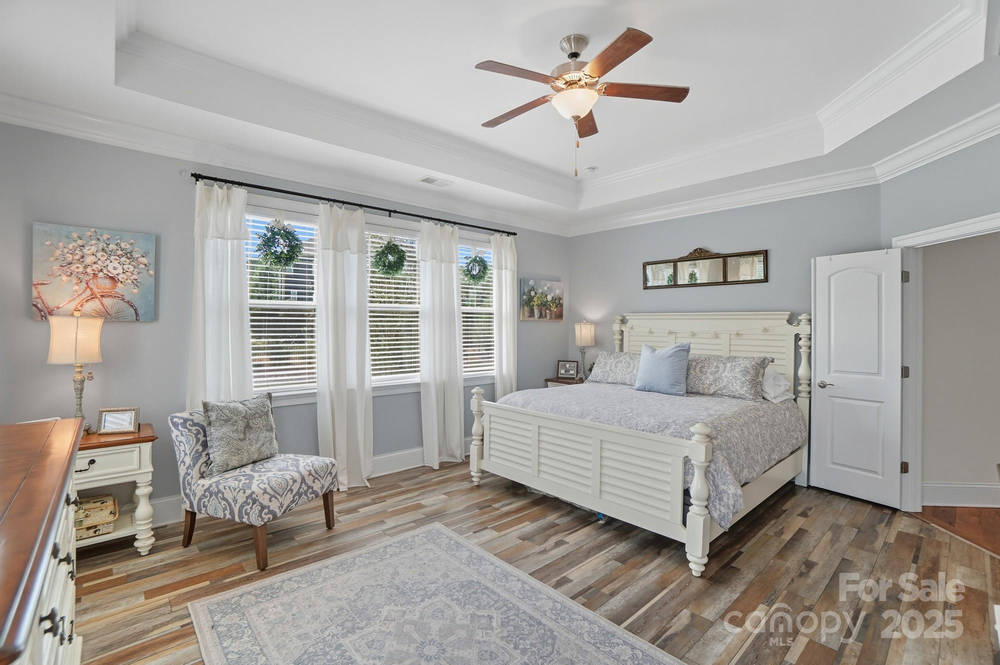 546 Abelia Lane Fort Mill, SC 29708 - Photo 23 of 43 a spacious bedroom with a large bed and a chandelier