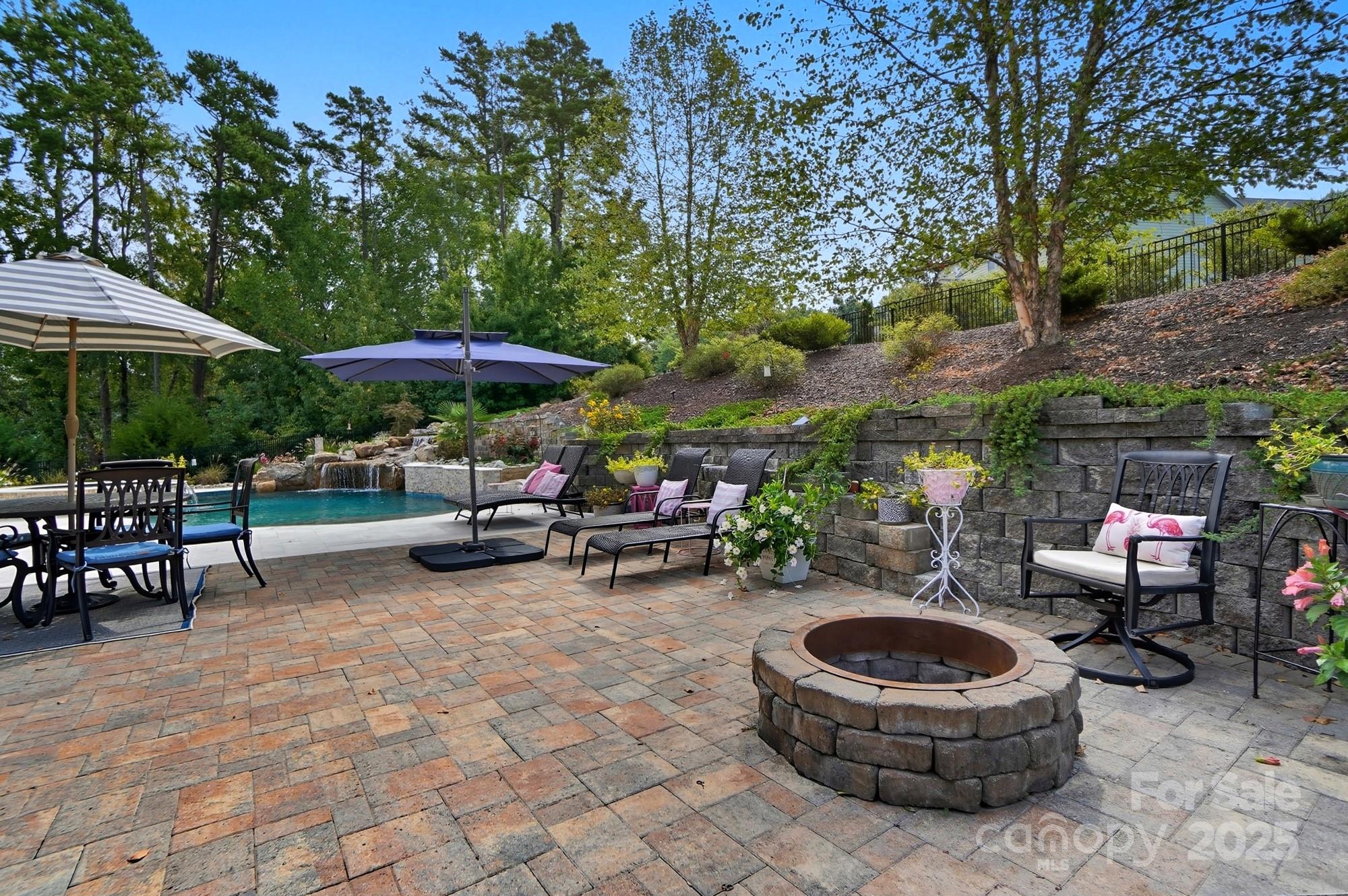 546 Abelia Lane Fort Mill, SC 29708 - Photo 36 of 43 a view of a patio with dining table and chairs under an umbrella