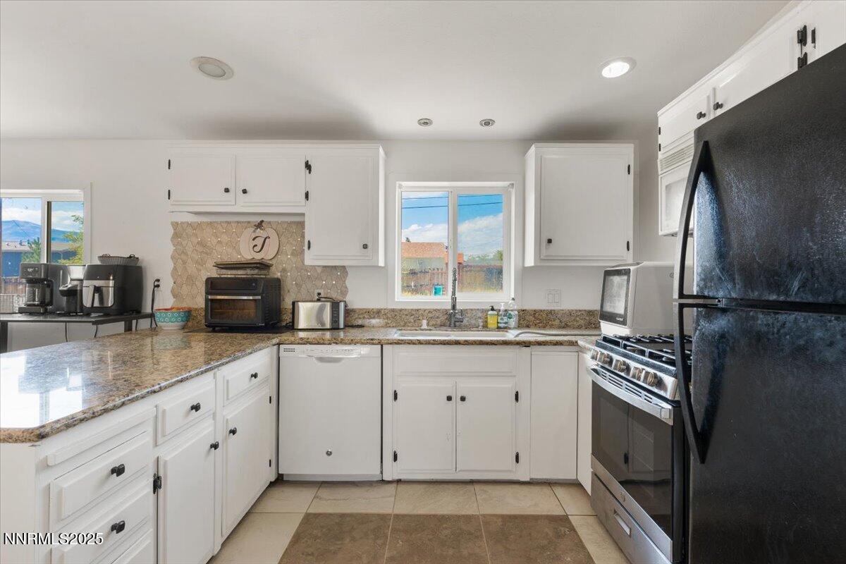 17570 Thrush Lane Reno, NV 89508 - Photo 11 of 30 a kitchen with granite countertop a refrigerator a sink and white cabinets