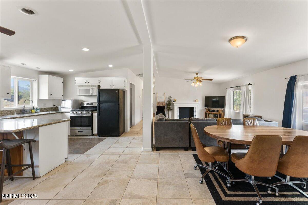 17570 Thrush Lane Reno, NV 89508 - Photo 5 of 30 a kitchen with stainless steel appliances kitchen island granite countertop a table chairs microwave and sink