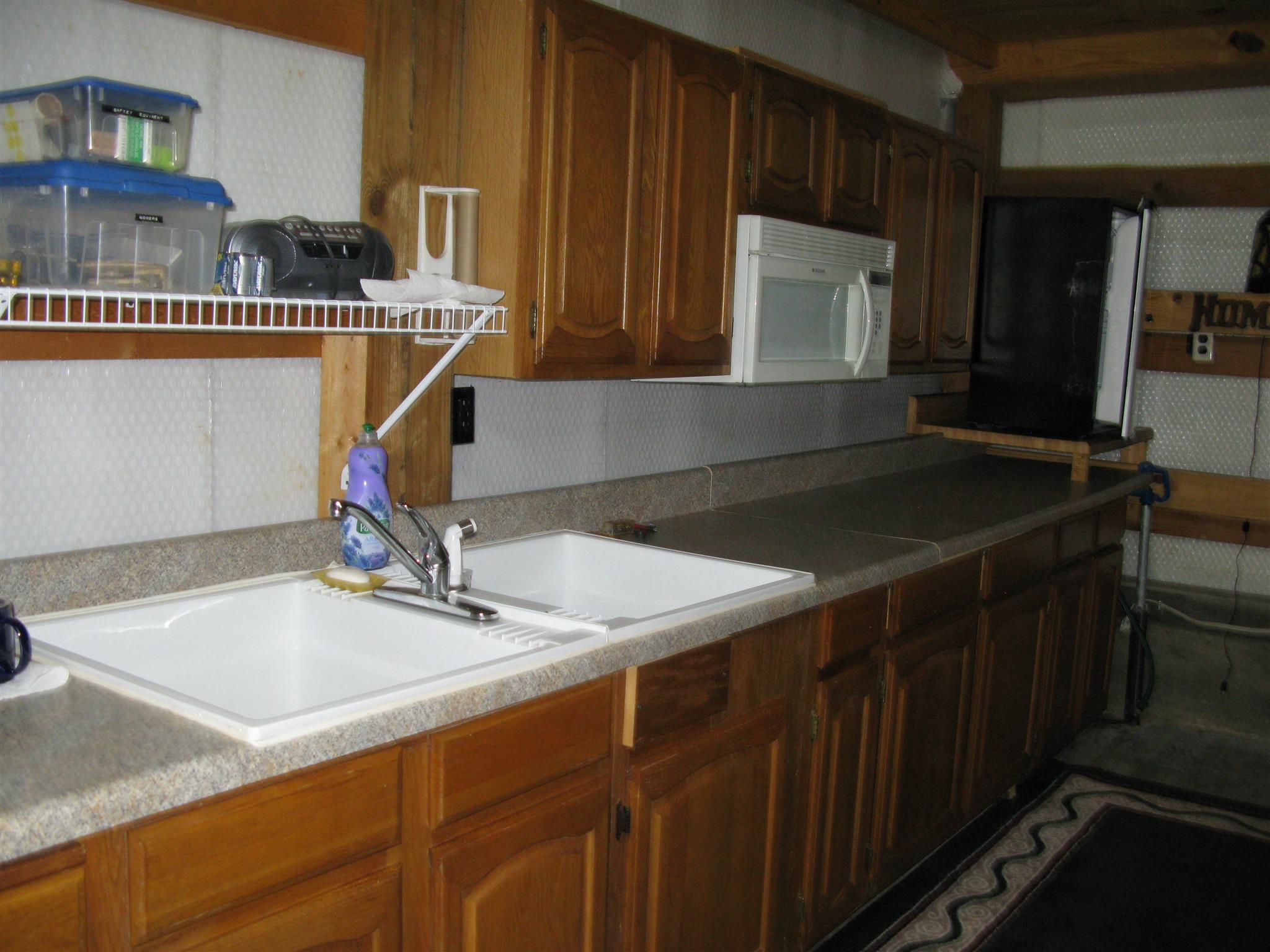 171 Poorhouse Road Taft, TN 38488 - Photo 25 of 27 a kitchen with a sink a cabinets and chairs