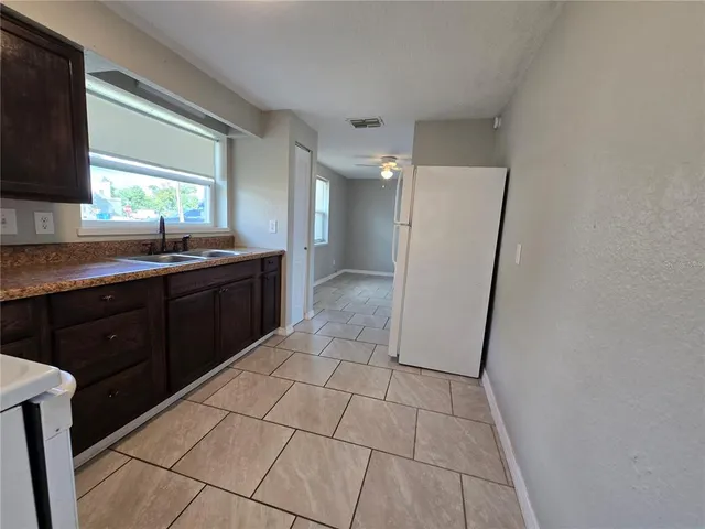 a kitchen with a sink a refrigerator and a stove top oven