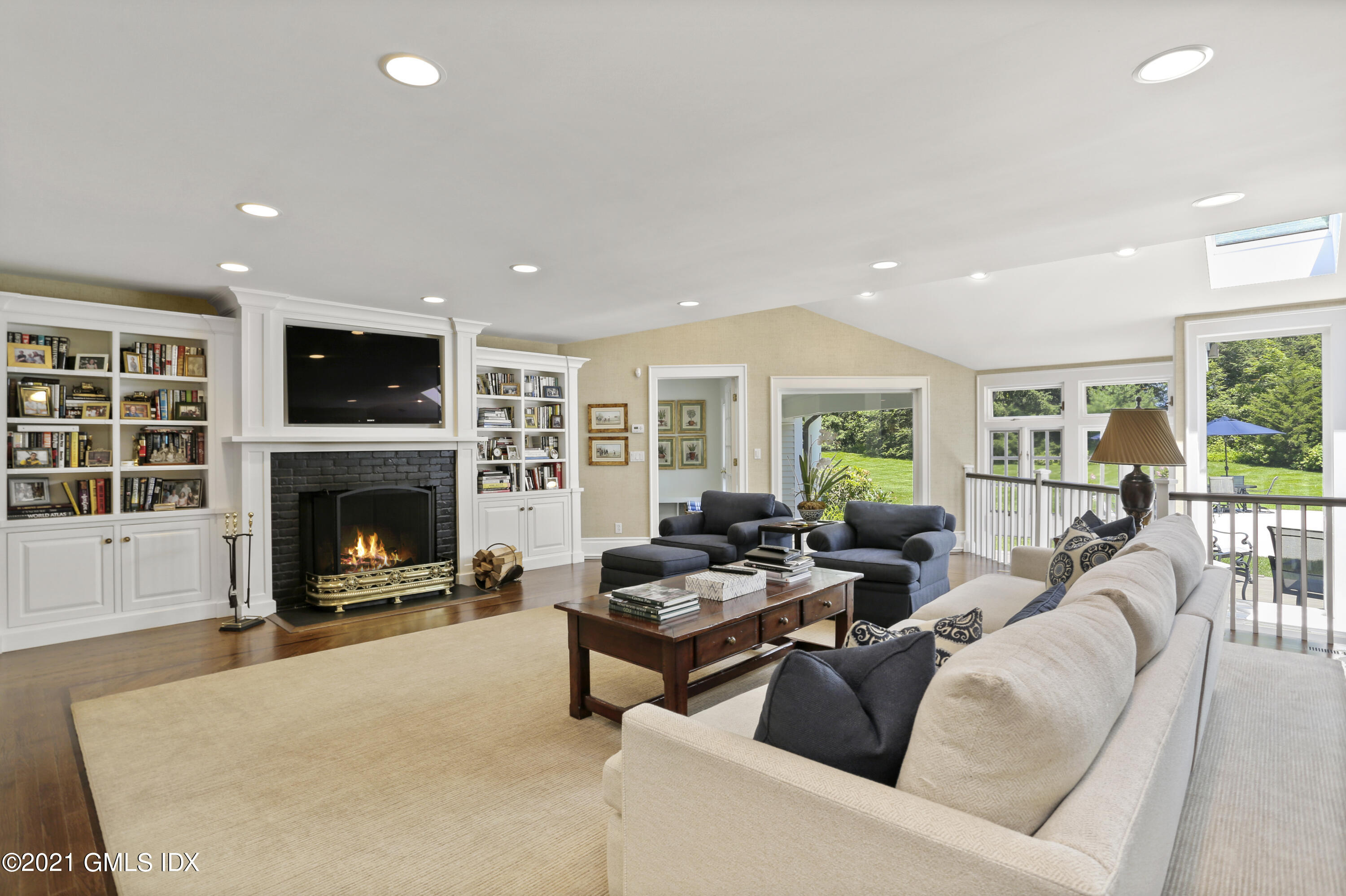 557 Round Hill Road Greenwich, CT 06831 - Photo 7 of 26 a living room with furniture a fireplace and a flat screen tv