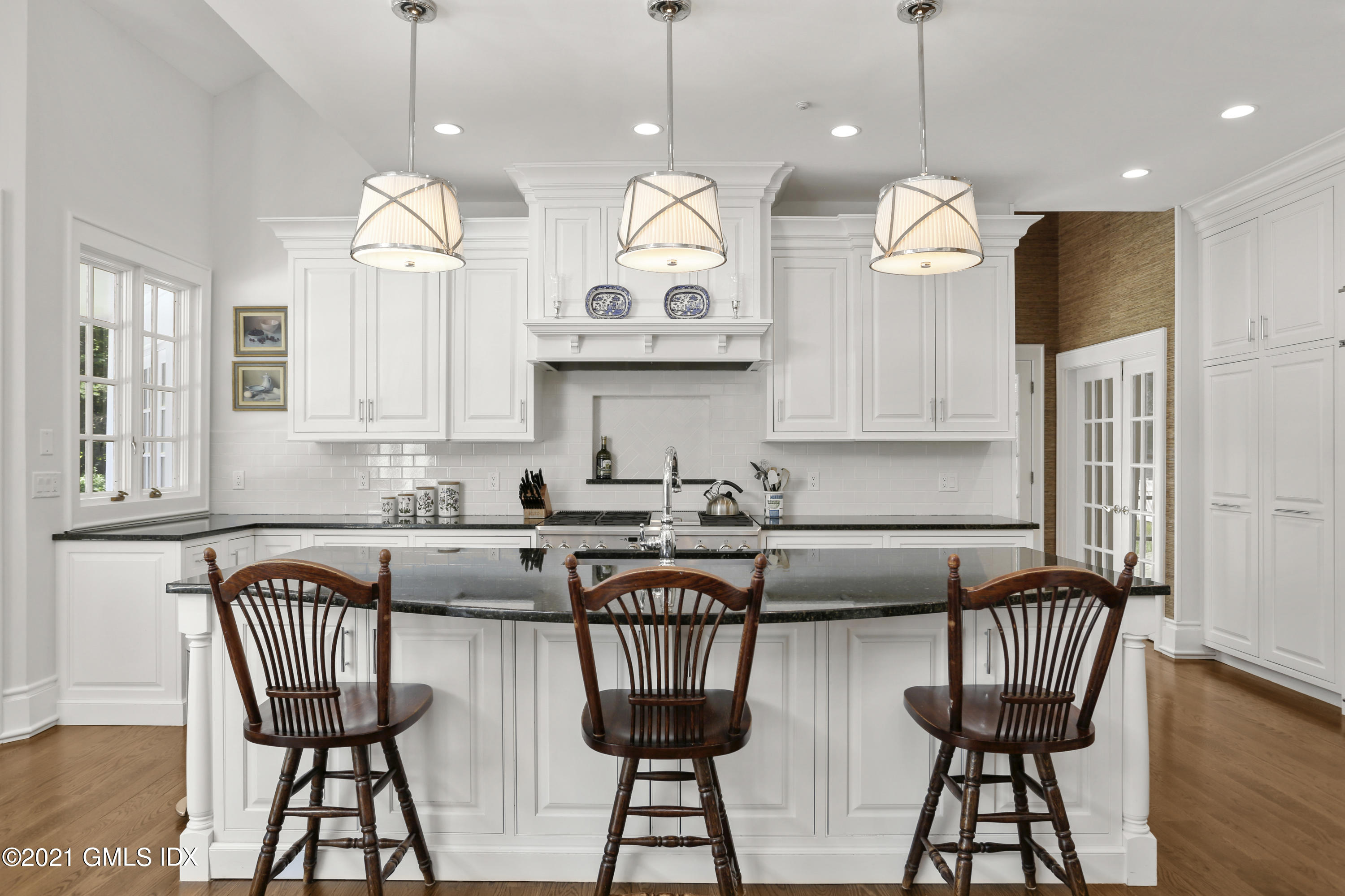 557 Round Hill Road Greenwich, CT 06831 - Photo 10 of 26 a kitchen with stainless steel appliances granite countertop a stove a kitchen island a dining table and chairs