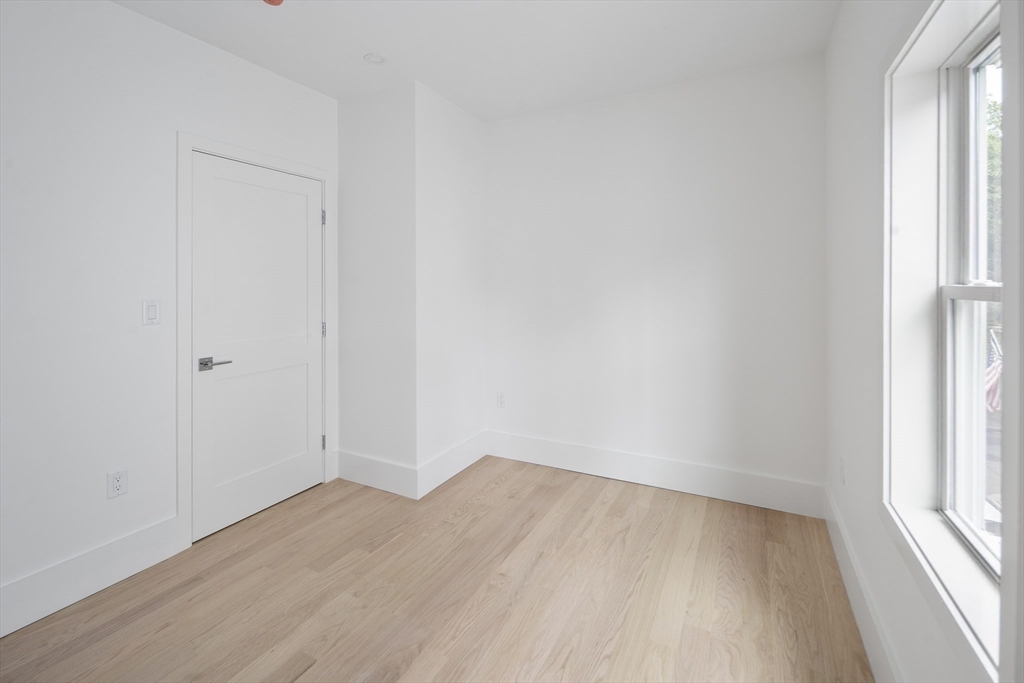 12-14 Edwin Street, Unit B Brookline, MA 02445 - Photo 12 of 18 an empty room with wooden floor and windows
