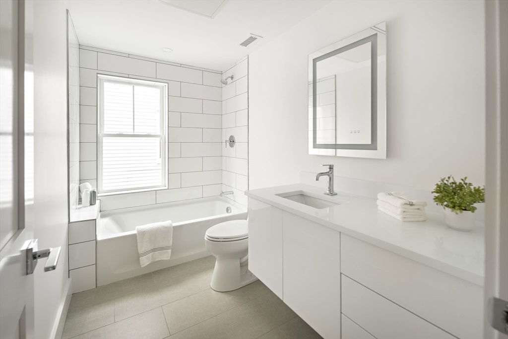 12-14 Edwin Street, Unit B Brookline, MA 02445 - Photo 14 of 18 a bathroom with a double vanity sink toilet and shower