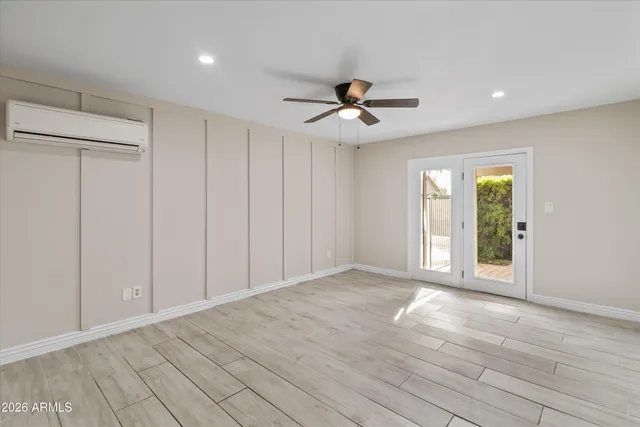 a view of empty room with wooden floor and fan