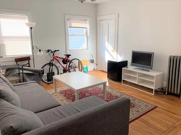 a living room with furniture a fireplace and a window