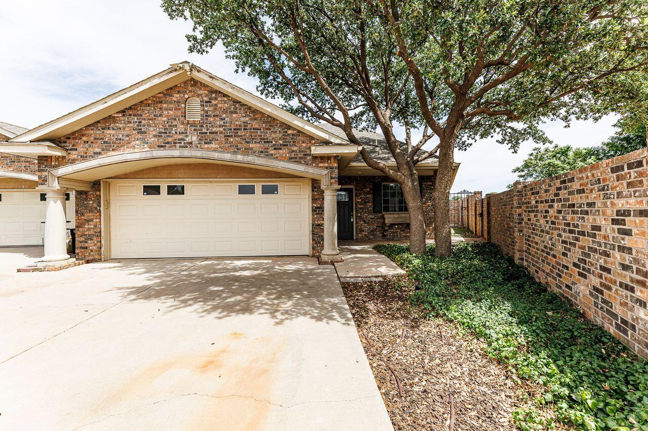 5811 11th Place, Unit 9 Lubbock, TX 79416 - Photo 1 of 50 a front view of a house with garden
