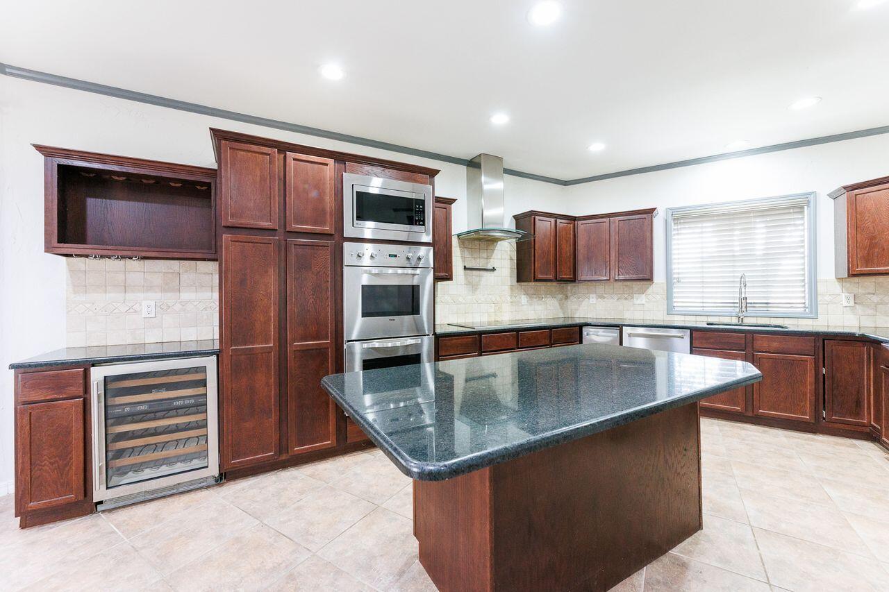 5811 11th Place, Unit 9 Lubbock, TX 79416 - Photo 11 of 50 a kitchen with stainless steel appliances granite countertop a sink and a refrigerator