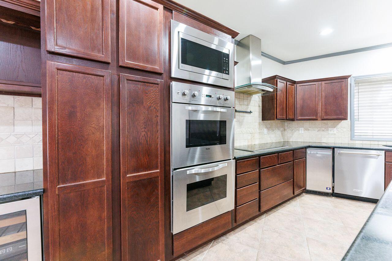 5811 11th Place, Unit 9 Lubbock, TX 79416 - Photo 12 of 50 a kitchen with stainless steel appliances granite countertop a refrigerator and a sink
