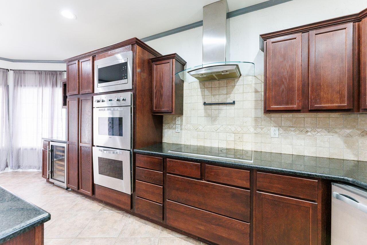 5811 11th Place, Unit 9 Lubbock, TX 79416 - Photo 15 of 50 a kitchen with stainless steel appliances granite countertop a refrigerator and a sink