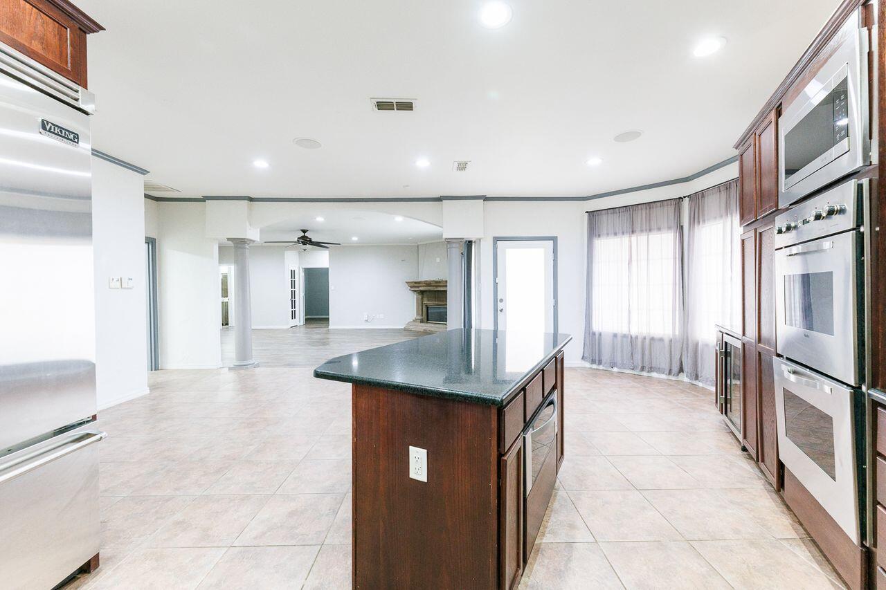 5811 11th Place, Unit 9 Lubbock, TX 79416 - Photo 17 of 50 a kitchen with stainless steel appliances granite countertop a refrigerator a sink and a stove