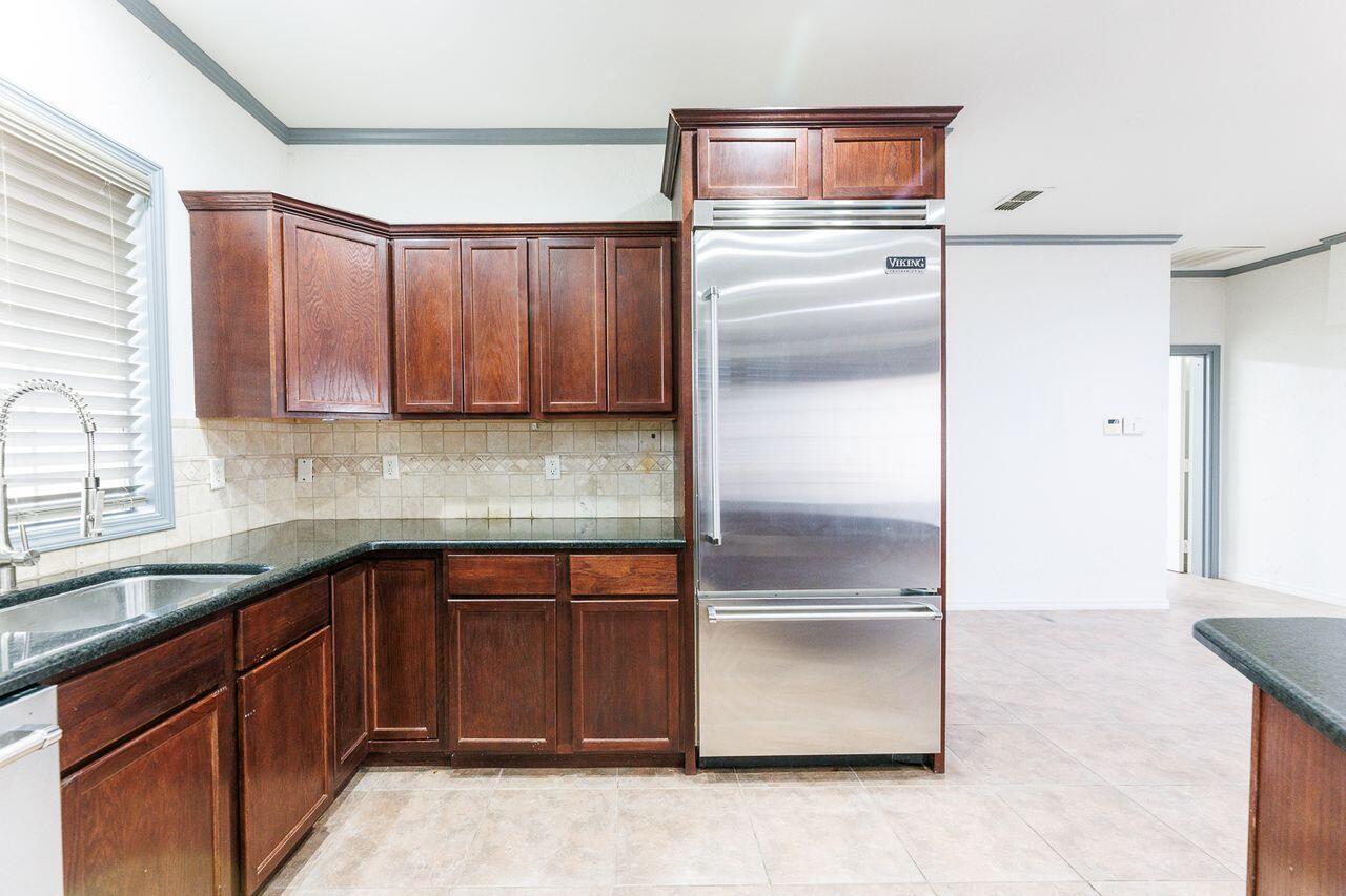 5811 11th Place, Unit 9 Lubbock, TX 79416 - Photo 18 of 50 a kitchen with a refrigerator and a sink