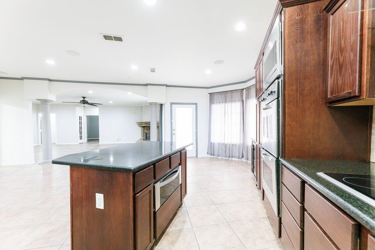5811 11th Place, Unit 9 Lubbock, TX 79416 - Photo 19 of 50 a kitchen with stainless steel appliances granite countertop a sink and a refrigerator