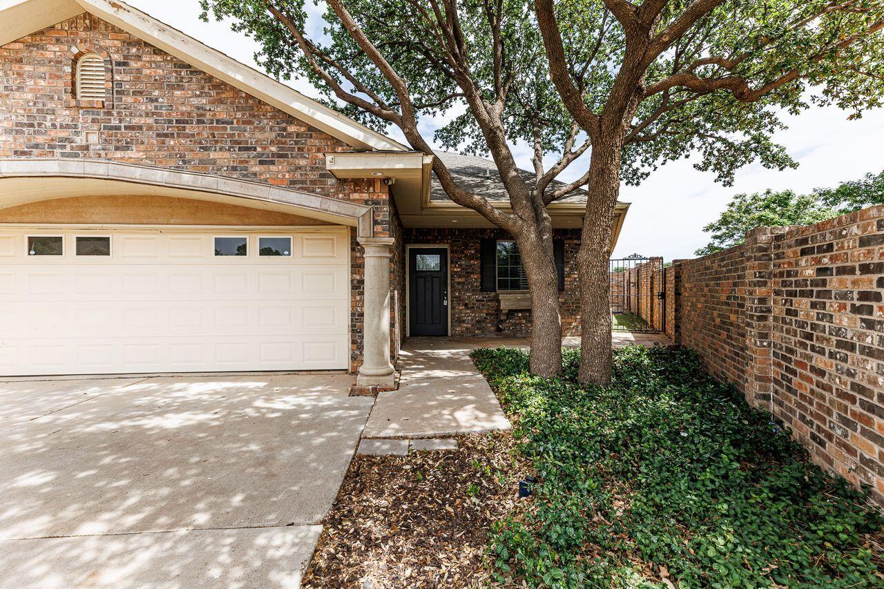 5811 11th Place, Unit 9 Lubbock, TX 79416 - Photo 2 of 50 a front view of a house with garden
