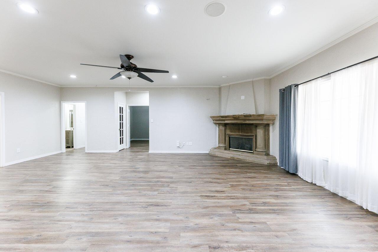 5811 11th Place, Unit 9 Lubbock, TX 79416 - Photo 22 of 50 an empty room with wooden floor fireplace and windows