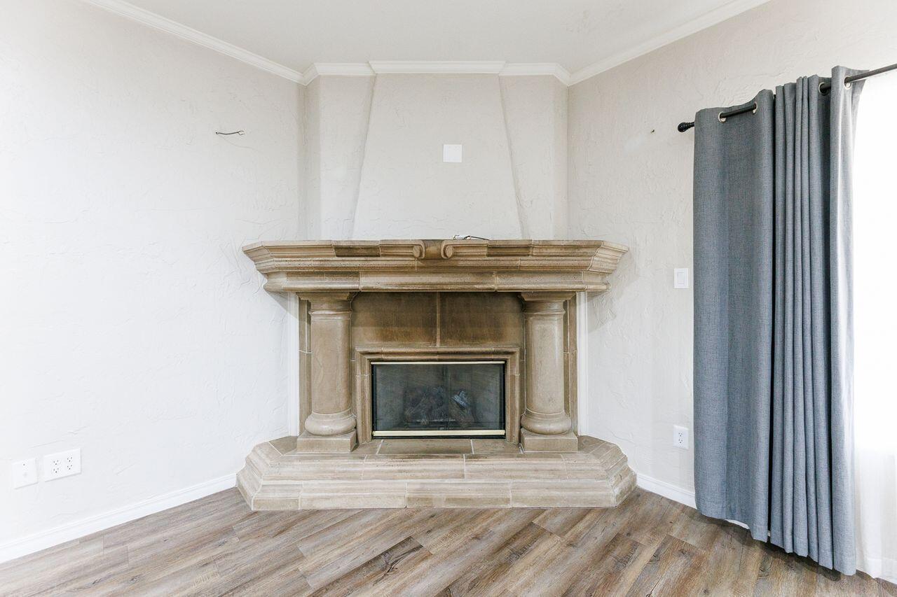 5811 11th Place, Unit 9 Lubbock, TX 79416 - Photo 23 of 50 a view of a livingroom with wooden floor and a fireplace