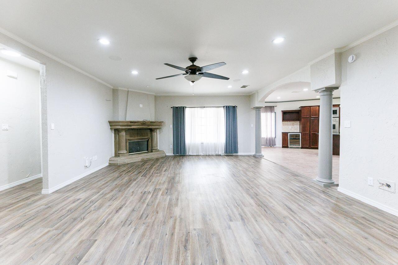 5811 11th Place, Unit 9 Lubbock, TX 79416 - Photo 26 of 50 an empty room with wooden floor fireplace and windows