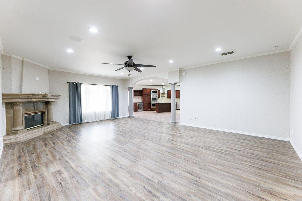 5811 11th Place, Unit 9 Lubbock, TX 79416 - Photo 27 of 50 an empty room with wooden floor fireplace and windows