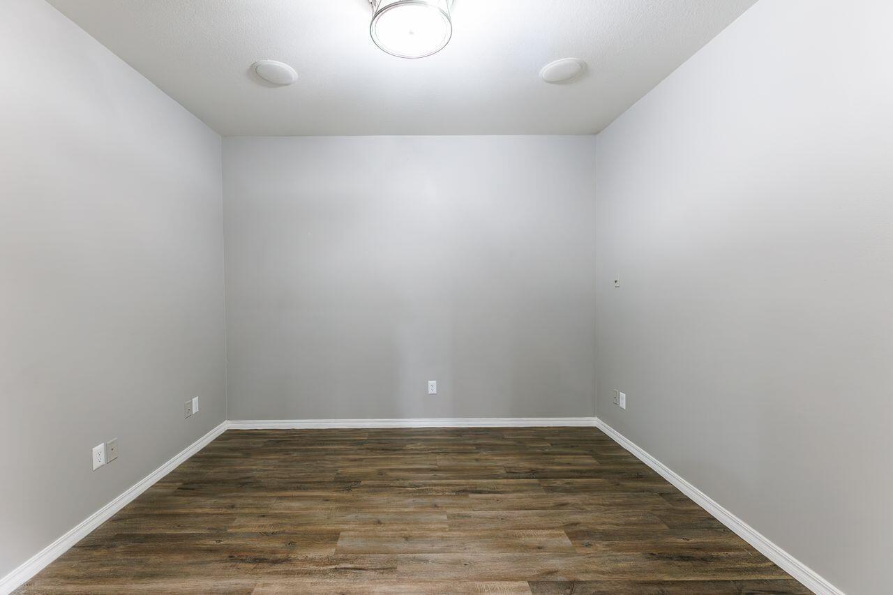 5811 11th Place, Unit 9 Lubbock, TX 79416 - Photo 31 of 50 a view of an empty room with wooden floor and white walls