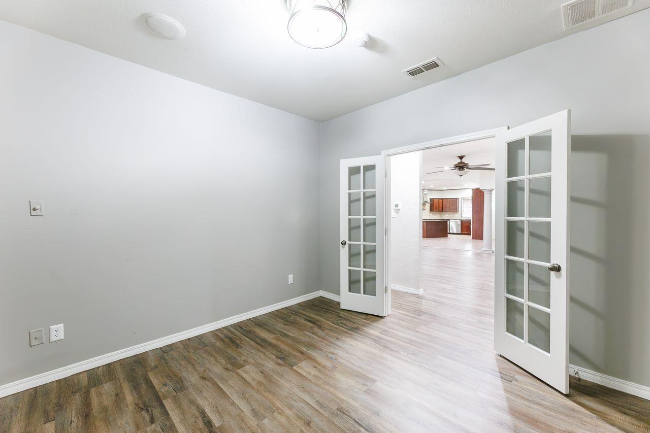 5811 11th Place, Unit 9 Lubbock, TX 79416 - Photo 32 of 50 an empty room with wooden floor and windows