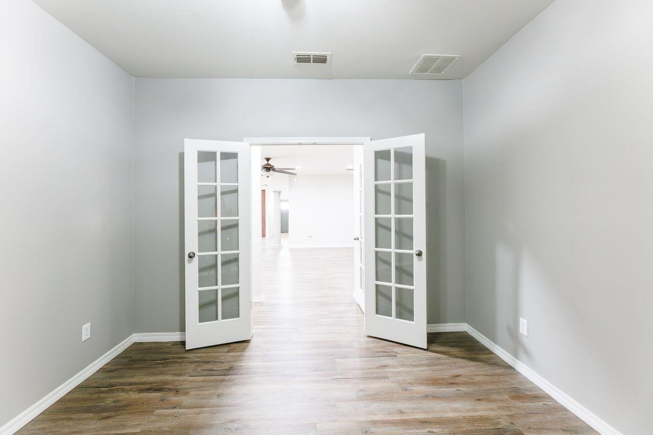 5811 11th Place, Unit 9 Lubbock, TX 79416 - Photo 33 of 50 an empty room with wooden floor and windows